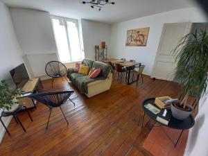 a living room with a couch and a table at Appartement, 2eme étage avec piscine partagée in Sedan