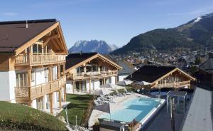 een gebouw met een zwembad en een resort bij Mountains Hotel in Seefeld in Tirol