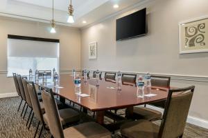 una sala de conferencias con una mesa larga con sillas y botellas de agua en Country Inn & Suites by Radisson, Tampa Airport North, FL, en Tampa