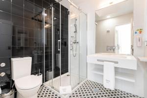 een badkamer met een douche, een toilet en een wastafel bij Soho Porto in Porto