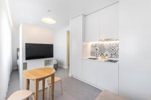 a living room with a table and a tv at Soho Porto in Porto