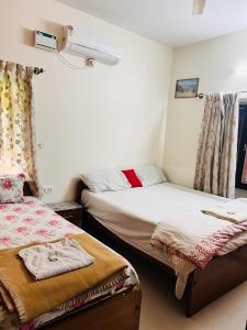 sypialnia z 2 łóżkami i oknem w obiekcie HSR Homestay Chethana w mieście Bengaluru