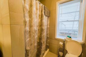 a bathroom with a shower curtain and a toilet at Spacious 3BR 3 Bath close to Niagara Falls in Niagara Falls