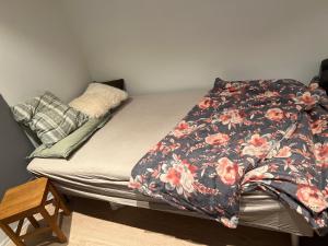 a bed with a flowered comforter on it at Morris Multi in Dar es Salaam