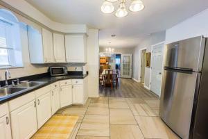 a kitchen with white cabinets and a stainless steel refrigerator at Spacious 3BR 3 Bath close to Niagara Falls in Niagara Falls