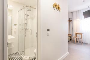 a bathroom with a glass shower with a toilet at Soho Porto in Porto +41 photos