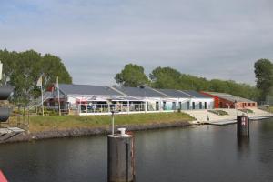 un grande edificio accanto a un corpo idrico di Herdersbrug Youth Hostel a Dudzele