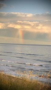 un arcobaleno nel cielo sopra l'oceano con una spiaggia di HOTEL MORASHÁ a Mar del Plata