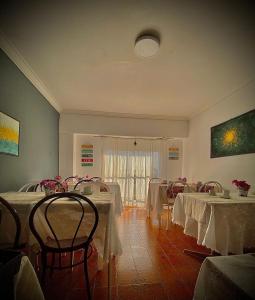 una stanza con diversi tavoli con tovaglie bianche di HOTEL MORASHÁ a Mar del Plata
