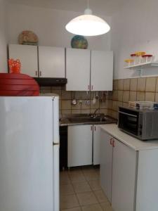 ランペドゥーザにあるSplendido appartamento a Lampedusa, con terrazzo !の白いキャビネット、シンク、電子レンジ付きのキッチンが備わります。