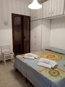 una camera da letto con un letto e due asciugamani di Splendido appartamento a Lampedusa, con terrazzo ! a Lampedusa