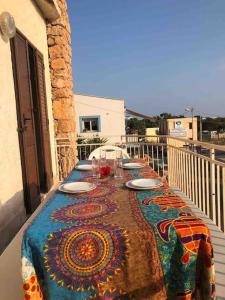 un tavolo con piatti e bicchieri da vino su un balcone di Splendido appartamento a Lampedusa, con terrazzo ! a Lampedusa