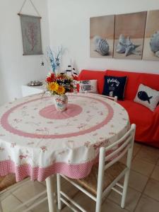 un tavolo con un vaso di fiori sopra di Splendido appartamento a Lampedusa, con terrazzo ! a Lampedusa