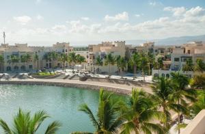 uma vista para um resort com palmeiras e uma piscina em Salalah Forest Island Villa em Ţāqah