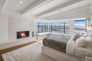 una camera da letto con camino e letto con vista sull'oceano di ৎ୭ Victoria ৎ୭ a Malibu