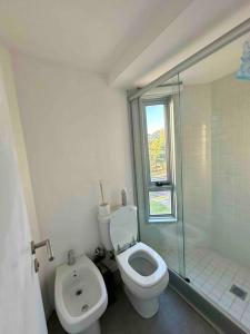 een witte badkamer met een toilet en een douche bij Apartamento nuevo super full in Punta del Este
