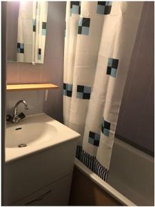 a bathroom with a sink and a shower curtain at Appartement 6 couchages aux pieds des pistes in Chamrousse