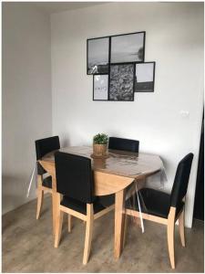 uma mesa de jantar com cadeiras pretas e uma mesa de madeira em Appartement 6 couchages aux pieds des pistes em Chamrousse