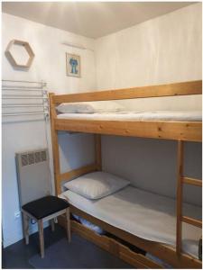 two bunk beds in a small room with a stool at Appartement 6 couchages aux pieds des pistes in Chamrousse