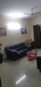 a living room with a blue couch and a table at Brookefield Service Apartment in Bangalore