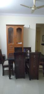a dining room with a table and chairs and a cabinet at Brookefield Service Apartment in Bangalore