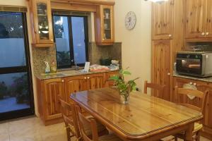 a kitchen with wooden cabinets and a wooden table at Ramla Boutique Home in Marsaskala