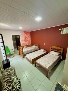 Zimmer mit 3 Betten in einem Zimmer in der Unterkunft Casa Jambo Hostel Para Mulheres in Guarujá