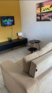 uma sala de estar com um sofá e uma televisão em Casa praia Serrambi em Porto de Galinhas