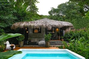 a small hut with a swimming pool in front of it at Coco Bungo - Beachside Bungalow #3 in Santa Teresa Beach