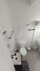 bagno bianco con servizi igienici e lavandino di Studio com bela vista para o mar a São Vicente