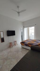 1 dormitorio con 1 cama y TV de pantalla plana en Studio com bela vista para o mar en São Vicente
