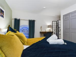 a bedroom with a bed with blue sheets and yellow pillows at Modern Duplex Central Free Parking Wi-Fi in Cheltenham