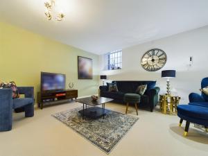 a living room with blue furniture and a tv at Modern Duplex Central Free Parking Wi-Fi in Cheltenham