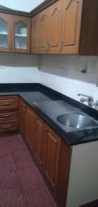 a kitchen with a black counter top and a sink at Brookefield Service Apartment in Bangalore