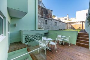 a balcony with tables and chairs on a building at Soho Porto in Porto