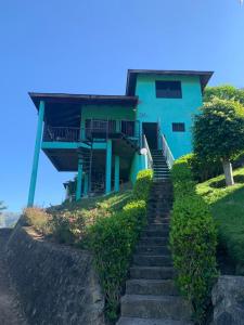 a blue house with stairs leading up to it at Villa Fe Esperanza - Vistas al Valle de Constanza in Constanza