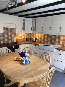 un tavolo in legno in una cucina con tavolo e sedie di Pontfair - Charming Cottage 10 mins walk from beach a Llangrannog