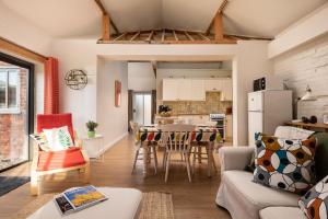 a kitchen and living room with a couch and a table at Wagtail in Fakenham