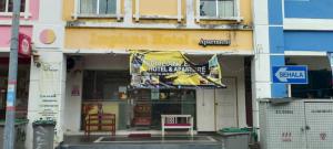 un negozio con uno striscione sul davanti di un edificio di Brilliant Empire Hotel a Malacca