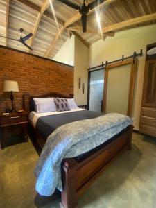 a bedroom with a bed and a brick wall at Paraiso Del Cielo in San Ramón