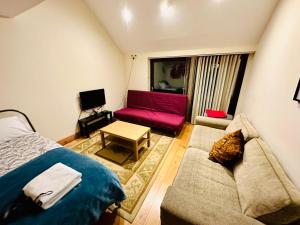 a living room with a couch and a red couch at London Mackenzie Suites in London