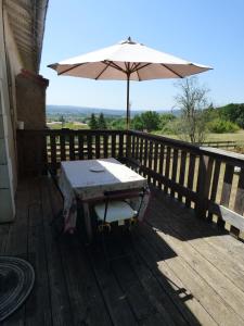 a table and an umbrella on a wooden deck at Domaine de la Borde in Puy-lʼÉvêque