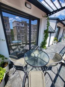 een patio met een glazen tafel en stoelen op een balkon bij AMAYA in Varna