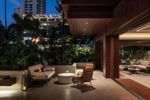 un patio avec des chaises et une table dans un bâtiment dans l'établissement Romer Waikiki at The Ambassador, à Honolulu