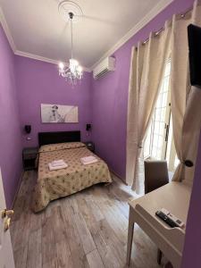 a purple bedroom with a bed and a table at Guest House Biondi Cavour in Rome +21 photos