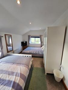 LlanenganにあるAbersoch Cottage llanenganの小さなベッドルーム(ベッド2台、冷蔵庫付)