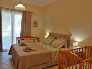 1 dormitorio con 1 cama con 2 toallas en Ιδανικό σπίτι διακοπών στο Λαγονήσι 5' από την θάλασσα & 20' από το αεροδρόμιο!, en Áyios Nikólaos