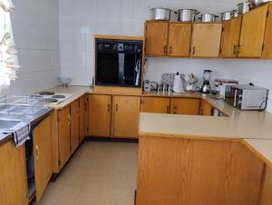 a kitchen with wooden cabinets and a black microwave at Rethapaki Guesthouse in Secunda
