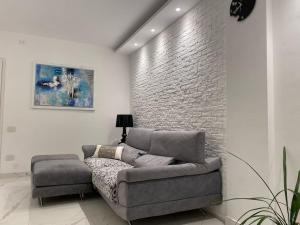 uma sala de estar com um sofá e uma parede de tijolos em Appartamento Luxury White em Viareggio