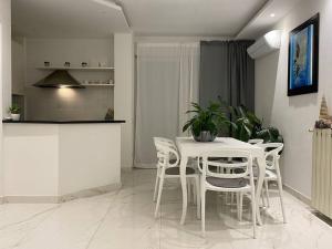 een witte eetkamer met een witte tafel en stoelen bij Appartamento Luxury White in Viareggio